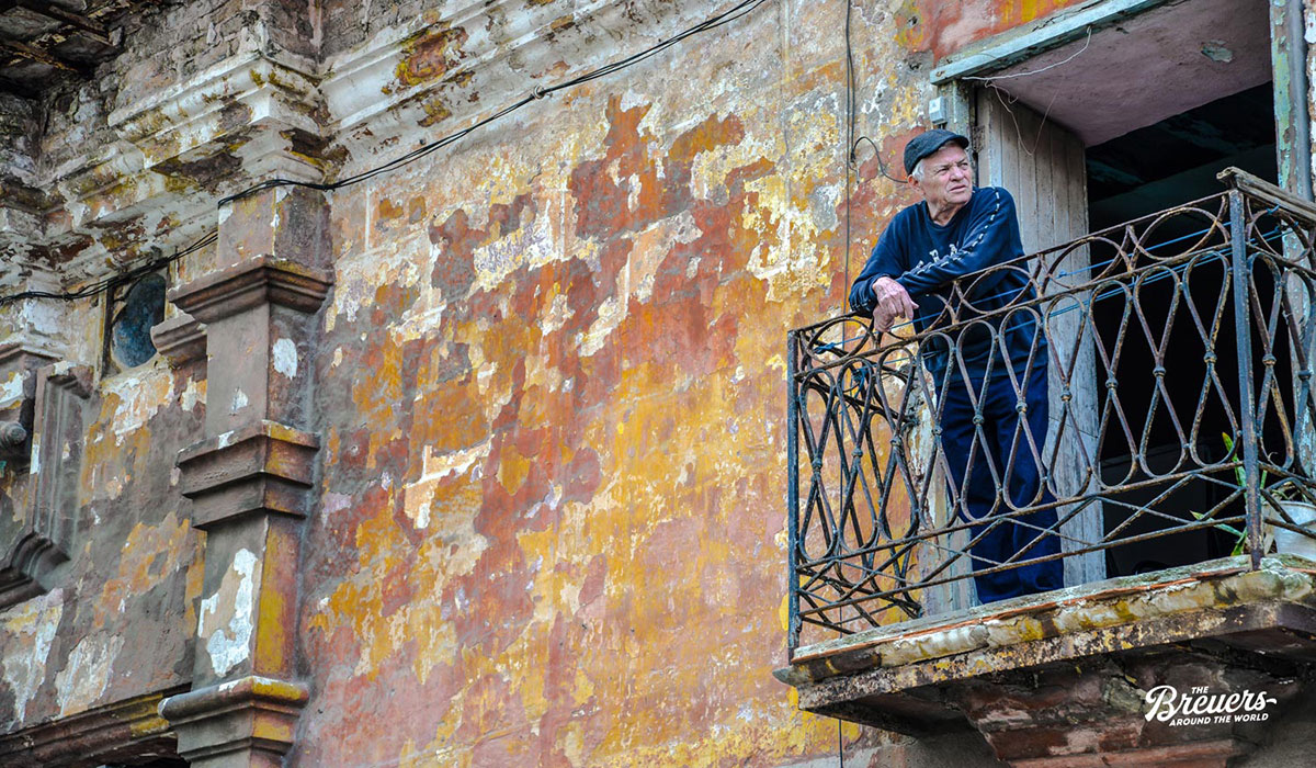 Alte bröckelnde Fassde mit einem Mann auf dem Balkon in der Altstadt von Havanna