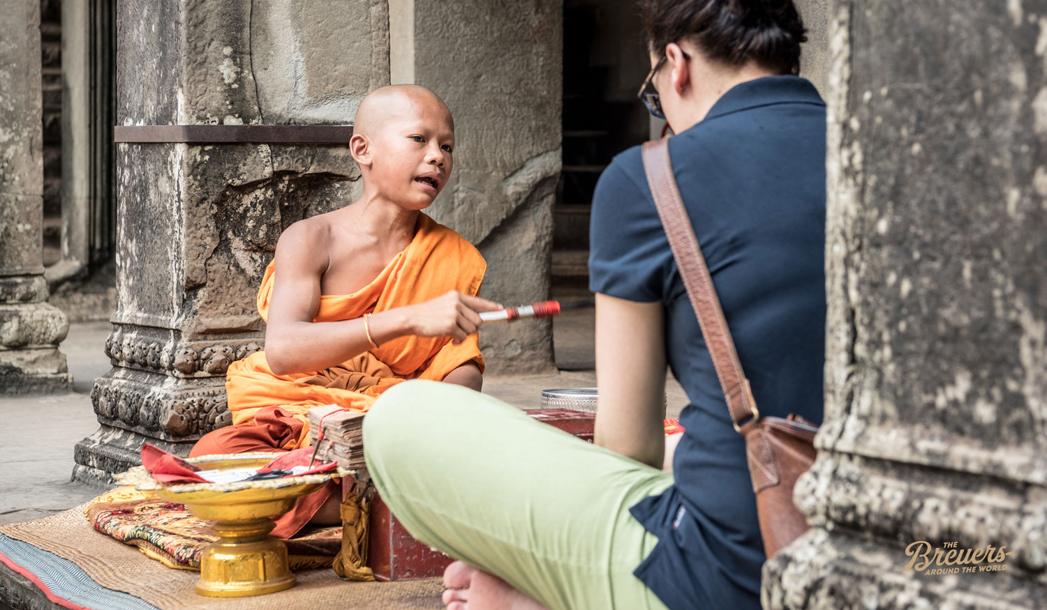 Kleiner Mönch segnet eine Touristin in Angkor Wat Kambodscha